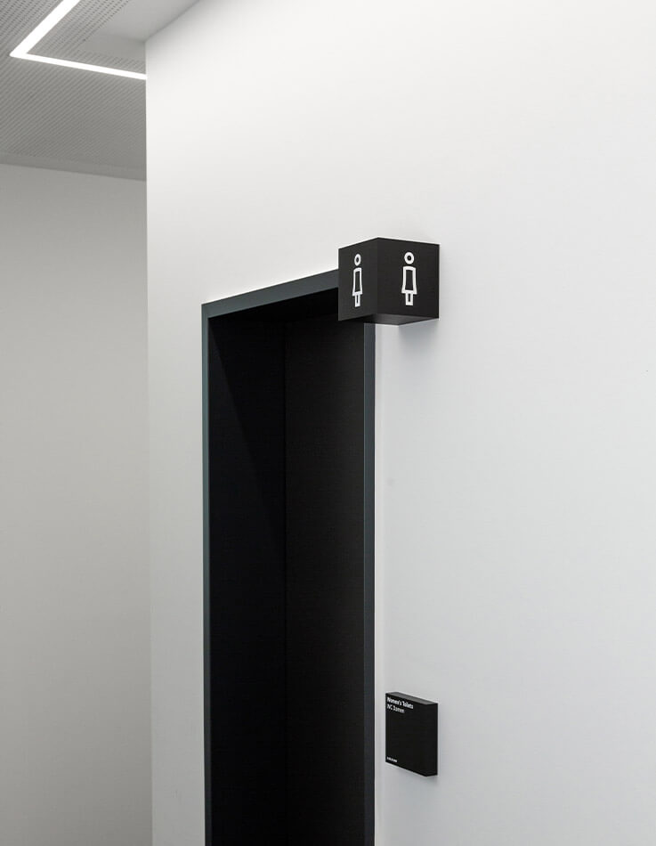 Auf diesem Foto ist das Türschild und der Piktogramm-Würfel des Damen-WCs zu sehen.