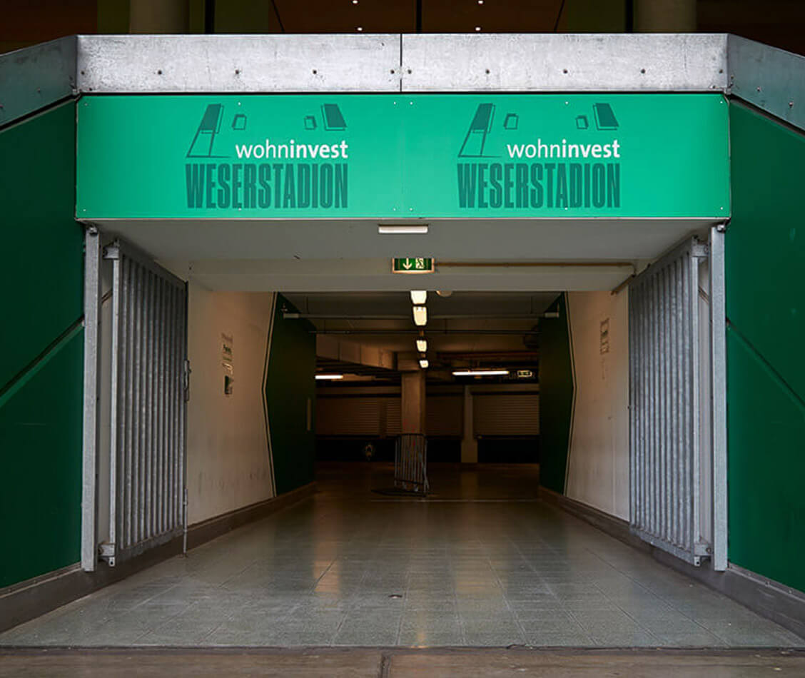 This picture shows the branding of a passage with the logo of the wohninvest WESERSTADION.