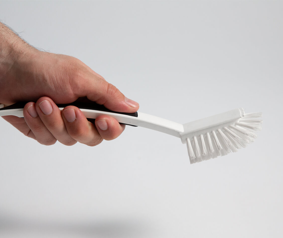 This picture shows how one hand grasps the ergonomic handle of the dishwashing brush.
