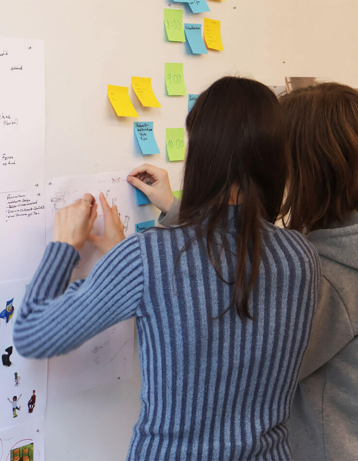 The two students researching and developing concepts on the whiteboard.