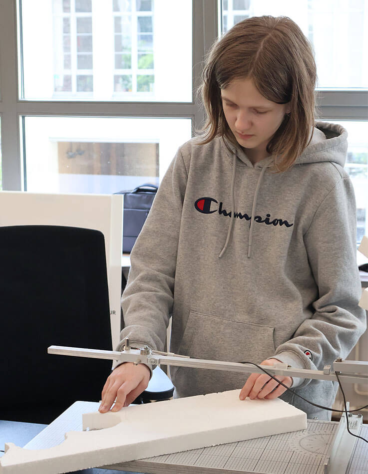 The student at the wire-cutting machine.